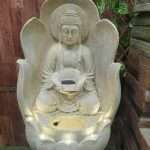 Buddha sitting on lotus flower water fountain
